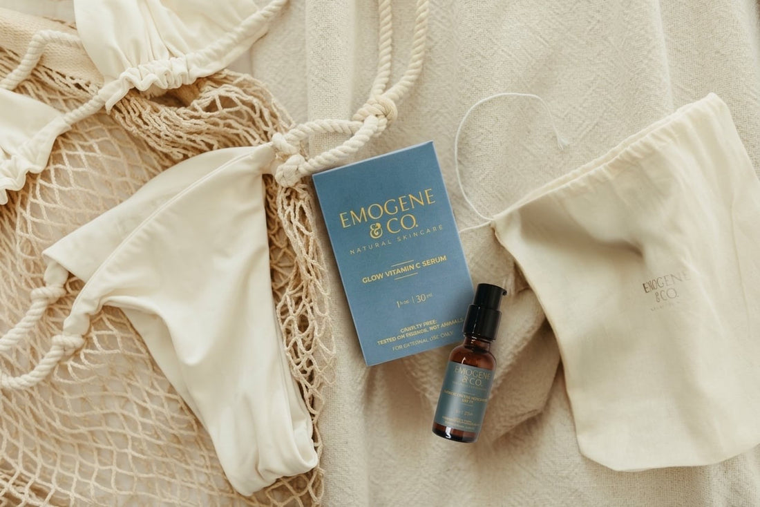 Summer Skin Essentials Glow Vitamin C Serum laying next to Radiant Tinted Moisturizer before being packed for a summer vacation next to bathing suit 